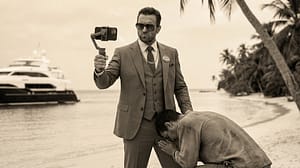 Ilustración satírica en tono sepia de un Robinson Crusoe moderno vistiendo traje formal y gafas de sol, tomándose una selfie como un político autoritario o influencer. Representación visual del individualismo neoliberal y el egoísmo en la política actual.